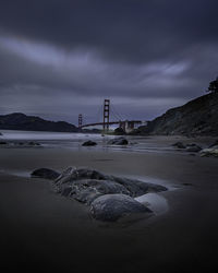 Bridge over sea shore against sky