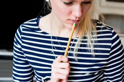 Close-up of thoughtful young woman holding pen