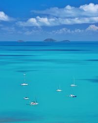 Sailboats in sea against sky