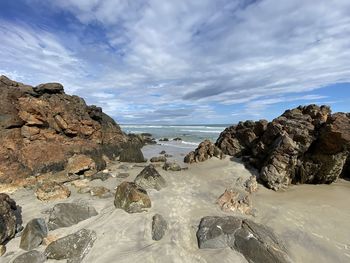 Rocks on beach against sky