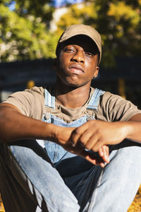 Portrait of young man looking away while sitting outdoors