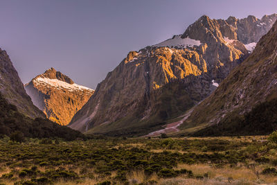 Panoramic view of land and mountains against clear sky