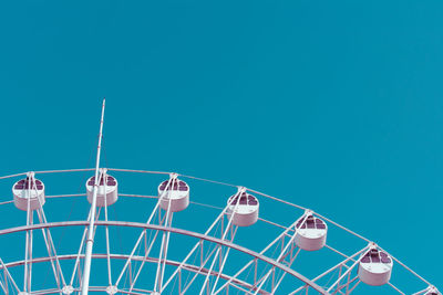 Low angle view of ferris wheel against blue sky