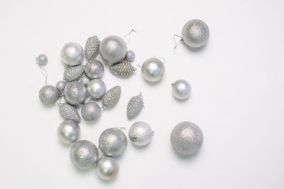 A set of silver christmas tree toys and decorations for the holiday lie on a white background