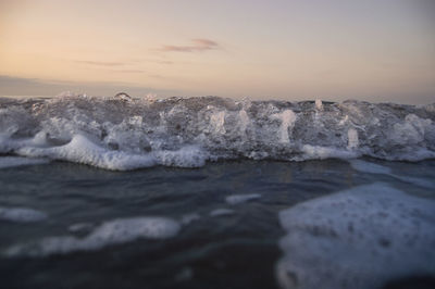 Waves rushing towards shore during sunset