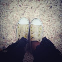 Close up of person standing on tiled floor