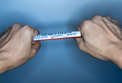 Close-up of hand holding blue wall