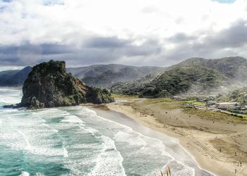 High angle view of rocky beach against cloudy sky