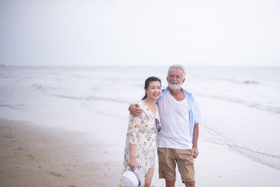 Elderly mix race couple walk on the beach