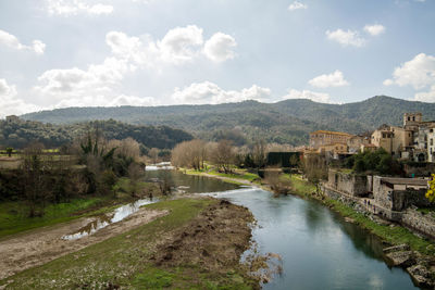 Scenic view of river by mountains against sky