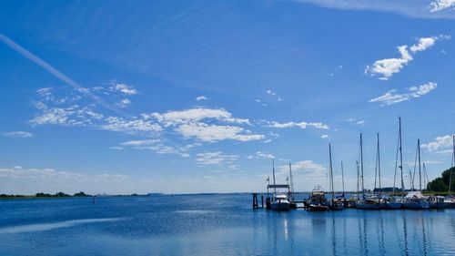 Sailboats in sea against blue sky