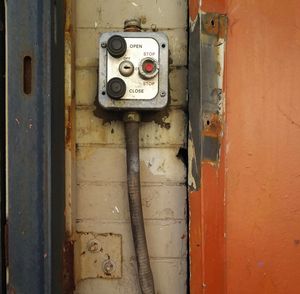 Close-up of old telephone booth on wall