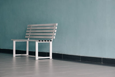 Empty bench against wall