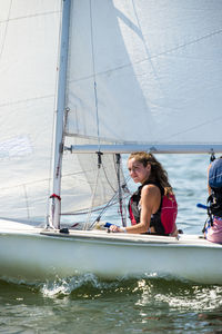 Female friends sitting on sailboat in sea