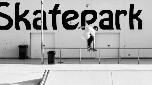 Man skateboarding at park against wall