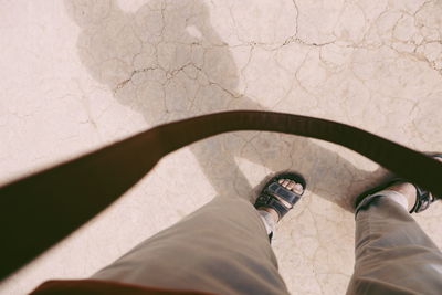 Low section of man standing by shadow on wall