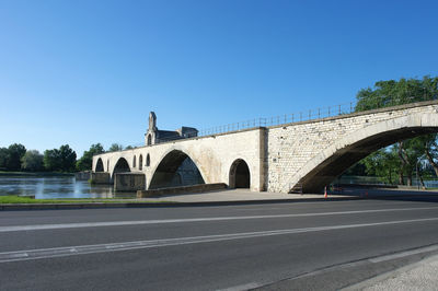 Arch bridge against clear blue sky in city