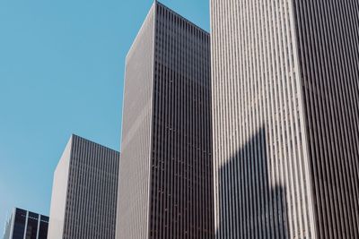 Low angle view of modern buildings against clear blue sky