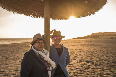 Portrait of senior women standing at beach during sunset