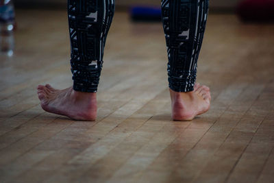 Low section of person standing on wooden floor