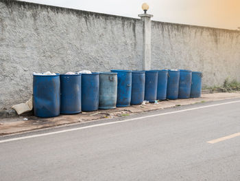 Row of garbage bin against building in city