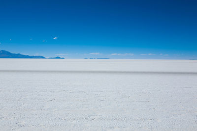 Scenic view of beach against blue sky