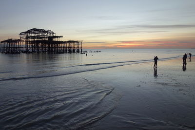 Brighton palace pier amidst sea during sunset