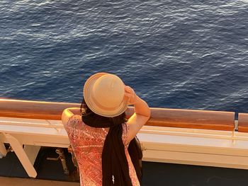 Rear view of woman in hat by sea