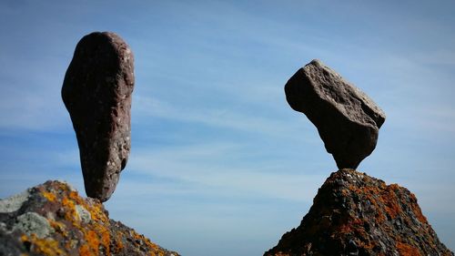 Low angle view of rocks against sky on sunny day