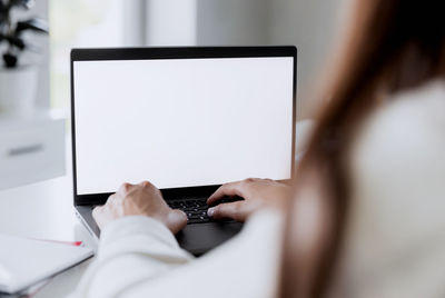 Midsection of woman using laptop