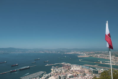 Aerial view of buildings in city against clear blue sky