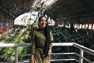 Portrait of young woman standing in city