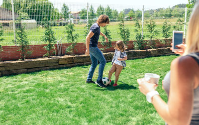 Woman photographing with mobile phone in grass