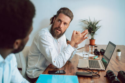 Man talking with faceless coworker in office