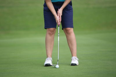 Low section of woman standing on golf course