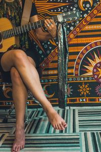 Low section of woman playing guitar