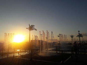 Silhouette palm trees against sky during sunset