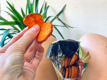 Close-up of hand holding orange