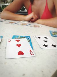 Midsection of woman playing cards on table