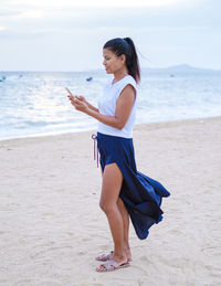 Side view of woman standing at beach