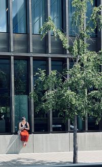 Woman with umbrella against building