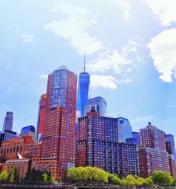 Low angle view of skyscrapers against cloudy sky