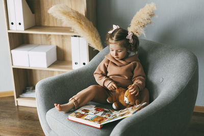 Boy sitting on sofa at home