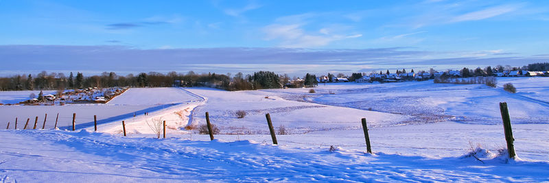 Scenic view of snow covered field against sky