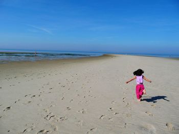 Full length of woman on beach against sky