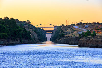 Bridge over river against sky during sunset