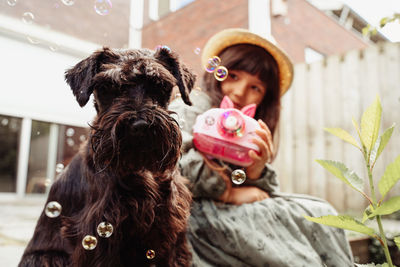 Close-up of dog sitting with little girl outside