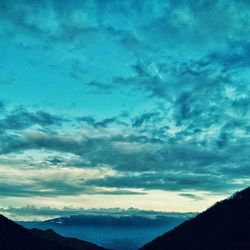 Scenic view of mountains against cloudy sky