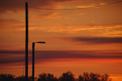 Low angle view of silhouette trees against dramatic sky