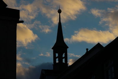 Low angle view of buildings against cloudy sky